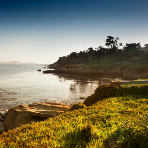 Photograph of a coastline and grass at sunset