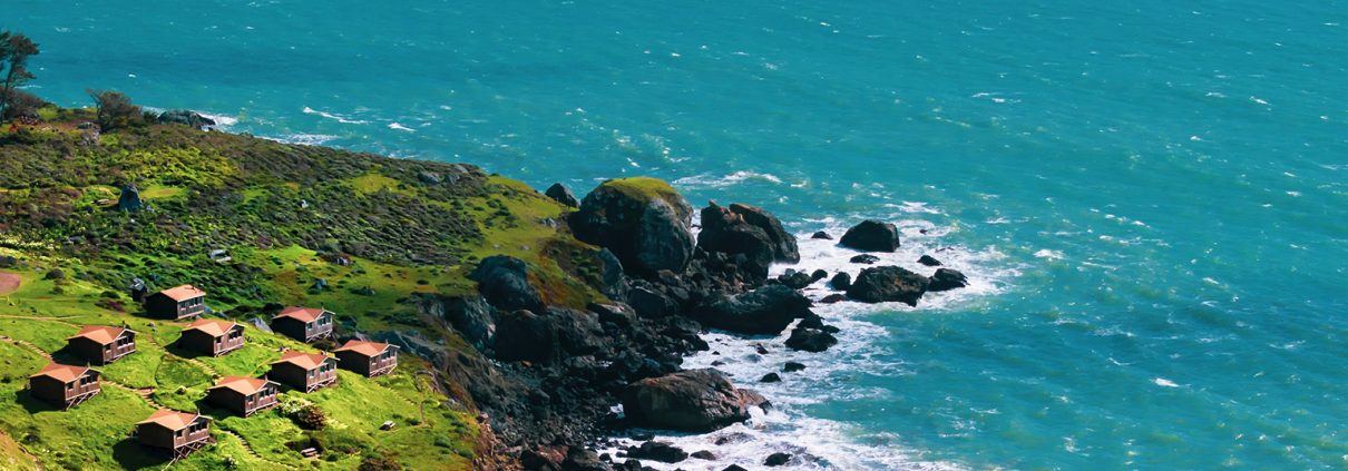 Aerial photo of a rocky coast with houses overlooking the water