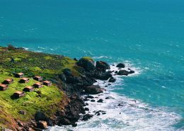 Aerial photo of a rocky coast with houses overlooking the water