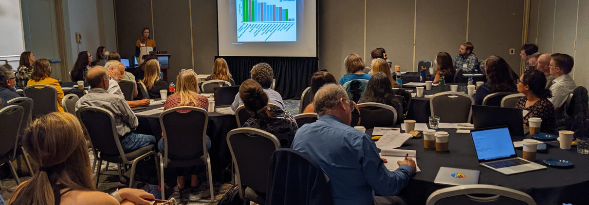 Photograph of a presenter speaking to a room of people at the West Coast Ocean Acidification and Hypoxia Symposium