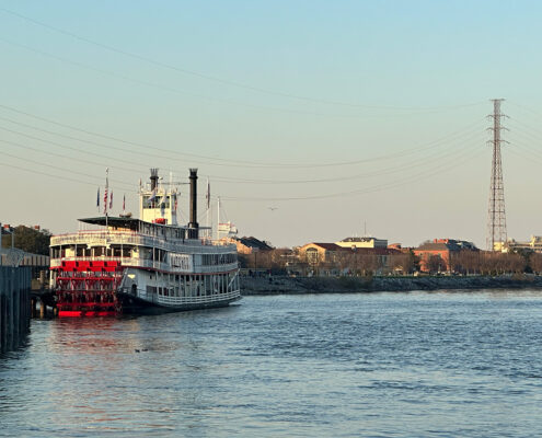 Photograph of an old steamboat in New Orleans at golden hour.